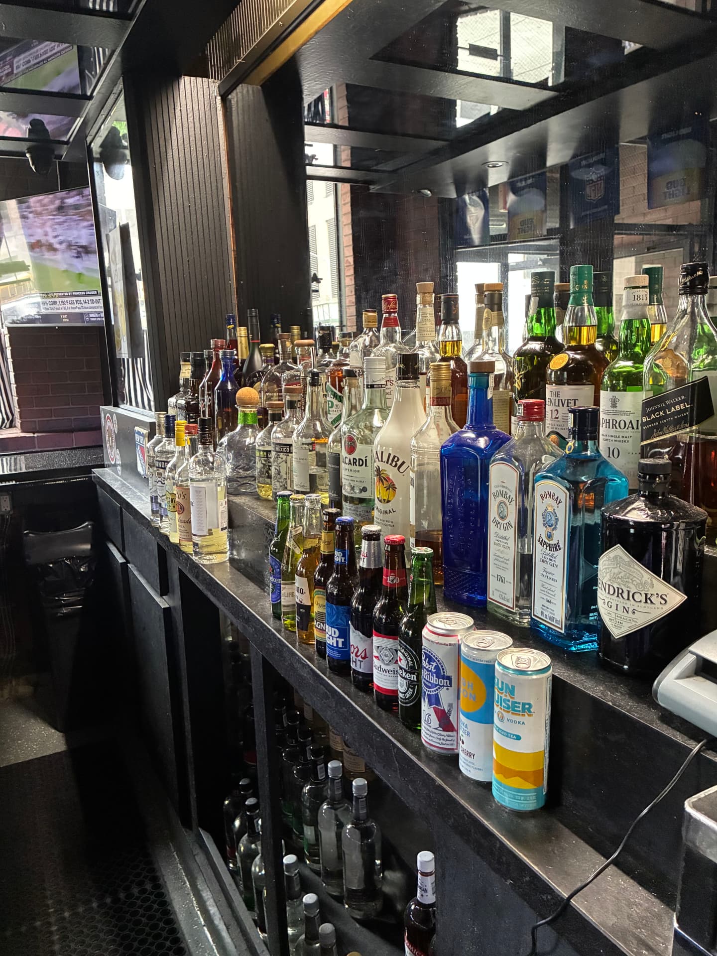 The back bar stocked with spirits and cans